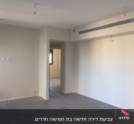קירות צבועים בלבן בחדר ריק עם רצפת אריחים אפורה